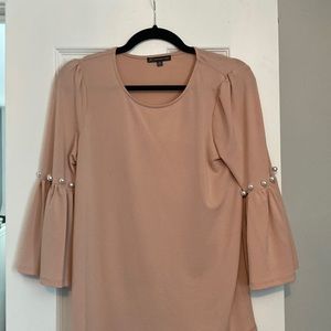 Pink blouse with pearl accessory on sleeves